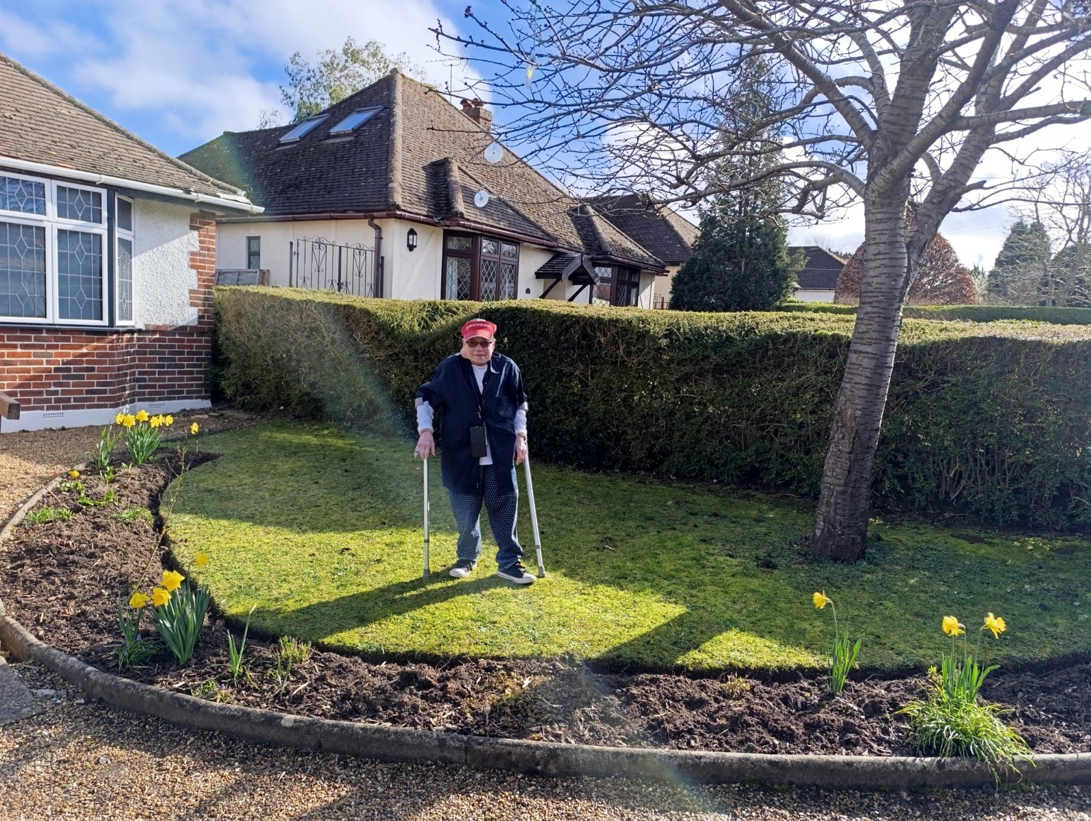 Sam standing outdoors using crutches